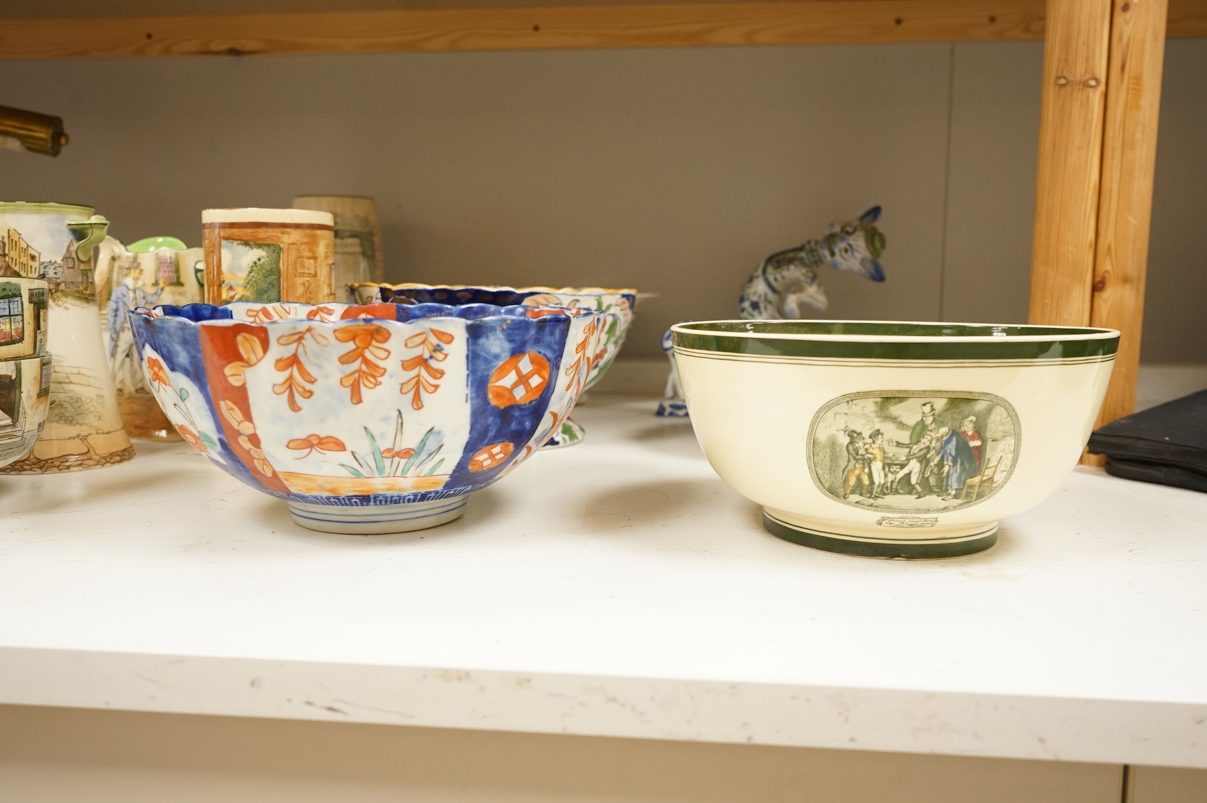 A collection of French, Japanese and English ceramics to include Royal Doulton Dickensware, Imari bowls and a faience glazed cat